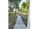 Large backyard featuring a wooden walkway leading to an outdoor dining area and entertainment space at 5365 Sw 111Th Lane Rd, Ocala, FL 34476
