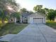 Charming single-story home with a well-manicured lawn and a long driveway leading to an attached two-car garage at 5365 Sw 111Th Lane Rd, Ocala, FL 34476