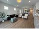 Bright living room features wood-look flooring, modern lighting, and neutral decor leading into the kitchen at 5785 Sw 87Th Court Rd, Ocala, FL 34481