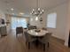 A combined living room and dining space, featuring a modern chandelier, and natural light at 5785 Sw 87Th Court Rd, Ocala, FL 34481