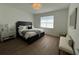 Inviting bedroom with dark wood-look floors, large window, and contemporary furnishings at 5785 Sw 87Th Court Rd, Ocala, FL 34481