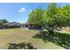 Spacious backyard featuring a view of the screened porch and a mature tree providing shade at 6057 Se 39Th Ave, Ocala, FL 34480