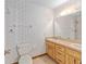 Bathroom featuring a dual sink vanity, wallpaper and a toilet, offering a functional layout at 6057 Se 39Th Ave, Ocala, FL 34480