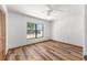 Bedroom featuring a ceiling fan, wood floor and a window offering natural light and comfort at 6057 Se 39Th Ave, Ocala, FL 34480