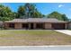 Charming single-story brick home with a well-manicured lawn, shutters, and a two-car garage at 6057 Se 39Th Ave, Ocala, FL 34480