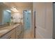 Bathroom featuring dual sinks, granite countertops, and view into open walk-in closet at 6132 Sw 94Th Ter, Ocala, FL 34481