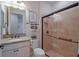 Bathroom with a granite-topped vanity and walk-in shower with a glass door at 6132 Sw 94Th Ter, Ocala, FL 34481