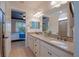 Bathroom with dual sinks, granite countertops, view into shower and bedroom at 6132 Sw 94Th Ter, Ocala, FL 34481