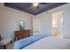 Bedroom features tray ceiling, tiled floor and view into the bathroom at 6132 Sw 94Th Ter, Ocala, FL 34481