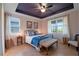 Comfortable bedroom featuring tray ceiling, two windows and matching bedside tables at 6132 Sw 94Th Ter, Ocala, FL 34481