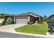 Charming home featuring a stone facade, two-car garage, landscaped yard, and a sidewalk leading to the front door at 6132 Sw 94Th Ter, Ocala, FL 34481