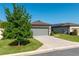 Charming home featuring a stone facade, two-car garage, landscaped yard, and a sidewalk leading to the front door at 6132 Sw 94Th Ter, Ocala, FL 34481
