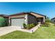 Charming home featuring a stone facade, two-car garage, landscaped yard, and a sidewalk leading to the front door at 6132 Sw 94Th Ter, Ocala, FL 34481