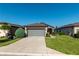 Charming home featuring a stone facade, two-car garage, landscaped yard, and a sidewalk leading to the front door at 6132 Sw 94Th Ter, Ocala, FL 34481