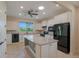 Bright kitchen with white cabinets, granite countertops, tile flooring, black appliances, and a center island at 6132 Sw 94Th Ter, Ocala, FL 34481