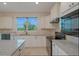 Bright kitchen featuring white cabinetry, granite countertops, black appliances, and a window over the sink at 6132 Sw 94Th Ter, Ocala, FL 34481