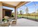 Enclosed lanai with wicker furniture and peaceful views of the backyard and landscaping at 6132 Sw 94Th Ter, Ocala, FL 34481