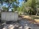 Outdoor view featuring a shed, lush trees, and a glimpse of the houses behind it at 621 Ne 20Th St, Ocala, FL 34470