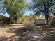 Exterior backyard view with a yellow house, a shed, and mature trees at 621 Ne 20Th St, Ocala, FL 34470