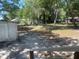 Backyard with shed, mature trees and a glimpse of other houses in the neighborhood at 621 Ne 20Th St, Ocala, FL 34470