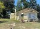 Quaint yellow cottage with white trim, chimney, and established landscaping at 621 Ne 20Th St, Ocala, FL 34470
