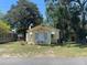 Charming, light yellow, one-story home with a well-maintained lawn and a classic white front door at 621 Ne 20Th St, Ocala, FL 34470