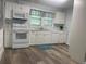 Modern kitchen with white cabinets, appliances, and wood laminate flooring at 621 Ne 20Th St, Ocala, FL 34470
