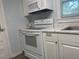 Well-lit kitchen featuring white appliances, a stainless steel sink, and light marble-look countertops at 621 Ne 20Th St, Ocala, FL 34470