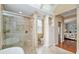 Bright bathroom featuring a soaking tub, glass-enclosed shower, and view to the Main Bedroom at 6882 Sw 113Th Pl, Ocala, FL 34476