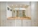 Double vanity bathroom with marble countertops, lots of storage, and large mirrors at 6882 Sw 113Th Pl, Ocala, FL 34476