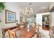 Dining room with chandelier, wood table, and view into the cozy living room, perfect for entertaining at 6882 Sw 113Th Pl, Ocala, FL 34476