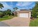 Well-maintained single-story home with brick driveway, mature landscaping, and a two-car garage at 6882 Sw 113Th Pl, Ocala, FL 34476
