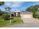 Charming single-story home with a manicured lawn, brick driveway, and a two-car garage at 6882 Sw 113Th Pl, Ocala, FL 34476