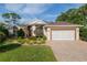 Stunning home with a beautiful lawn, landscaping, and a paved driveway leading to an attached two-car garage at 6882 Sw 113Th Pl, Ocala, FL 34476