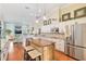 Gourmet kitchen featuring stainless steel appliances, an island with seating, and a view into the living room at 6882 Sw 113Th Pl, Ocala, FL 34476