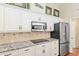 Kitchen featuring white cabinets, granite countertops, stainless appliances, and an island at 6882 Sw 113Th Pl, Ocala, FL 34476