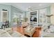 Bright living room with wood floors, built in shelves, and sliding glass doors to the pool at 6882 Sw 113Th Pl, Ocala, FL 34476