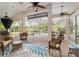 Screened-in patio features wicker furniture, overhead fans and overlooks the pool area and outdoor kitchen at 6882 Sw 113Th Pl, Ocala, FL 34476