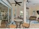 Covered patio space with overhead fans features wicker furniture and outdoor access via sliding glass doors at 6882 Sw 113Th Pl, Ocala, FL 34476