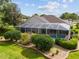 Backyard featuring a screened-in pool surrounded by decorative landscaping and a brick border at 6882 Sw 113Th Pl, Ocala, FL 34476