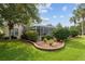 Backyard featuring a screened-in pool area with brick-lined landscaping and lush greenery at 6882 Sw 113Th Pl, Ocala, FL 34476