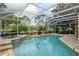 Screened-in pool area with beautiful landscaping, a spa, and outdoor seating at 6882 Sw 113Th Pl, Ocala, FL 34476