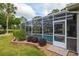 Backyard view of a screened-in pool with lush landscaping and a pool entrance at 6882 Sw 113Th Pl, Ocala, FL 34476