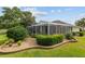 Backyard featuring a screened-in pool with decorative landscaping and lush green grass at 6882 Sw 113Th Pl, Ocala, FL 34476