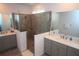 Modern bathroom featuring dual vanities, quartz countertops, and a frameless glass shower enclosure at 7429 Sw 61St St, Ocala, FL 34474