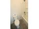 A compact bathroom with a toilet, a shower with shelves, and tiled floors at 7429 Sw 61St St, Ocala, FL 34474