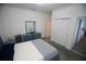 A bedroom features a bed with grey carpet, adjacent to double closets and bathroom entrance at 7429 Sw 61St St, Ocala, FL 34474