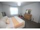 Cozy bedroom featuring carpet, window, modern dresser and a comfortable bed with stylish decor at 7429 Sw 61St St, Ocala, FL 34474