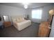 Comfortable bedroom featuring a tufted headboard, soft carpeting, and natural light from the window at 7429 Sw 61St St, Ocala, FL 34474