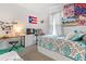 Charming bedroom featuring colorful decor, a large window, and a cozy bed with patterned bedding at 7571 Sw 64Th Street Rd, Ocala, FL 34474